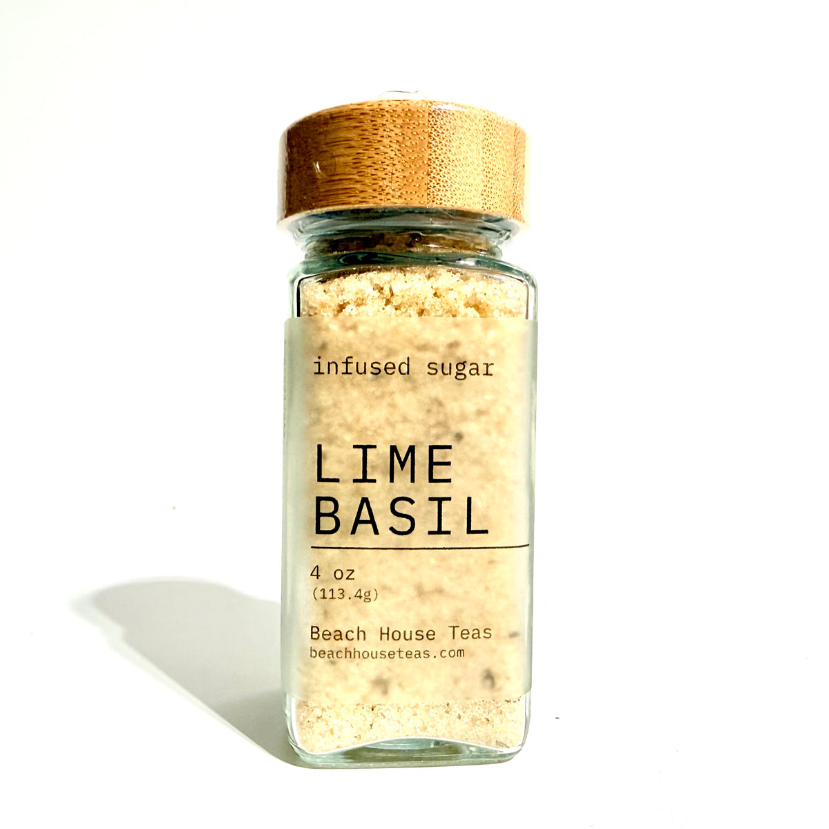 Lime Basil infused sugar 4 oz glass jar with a bamboo lid on white