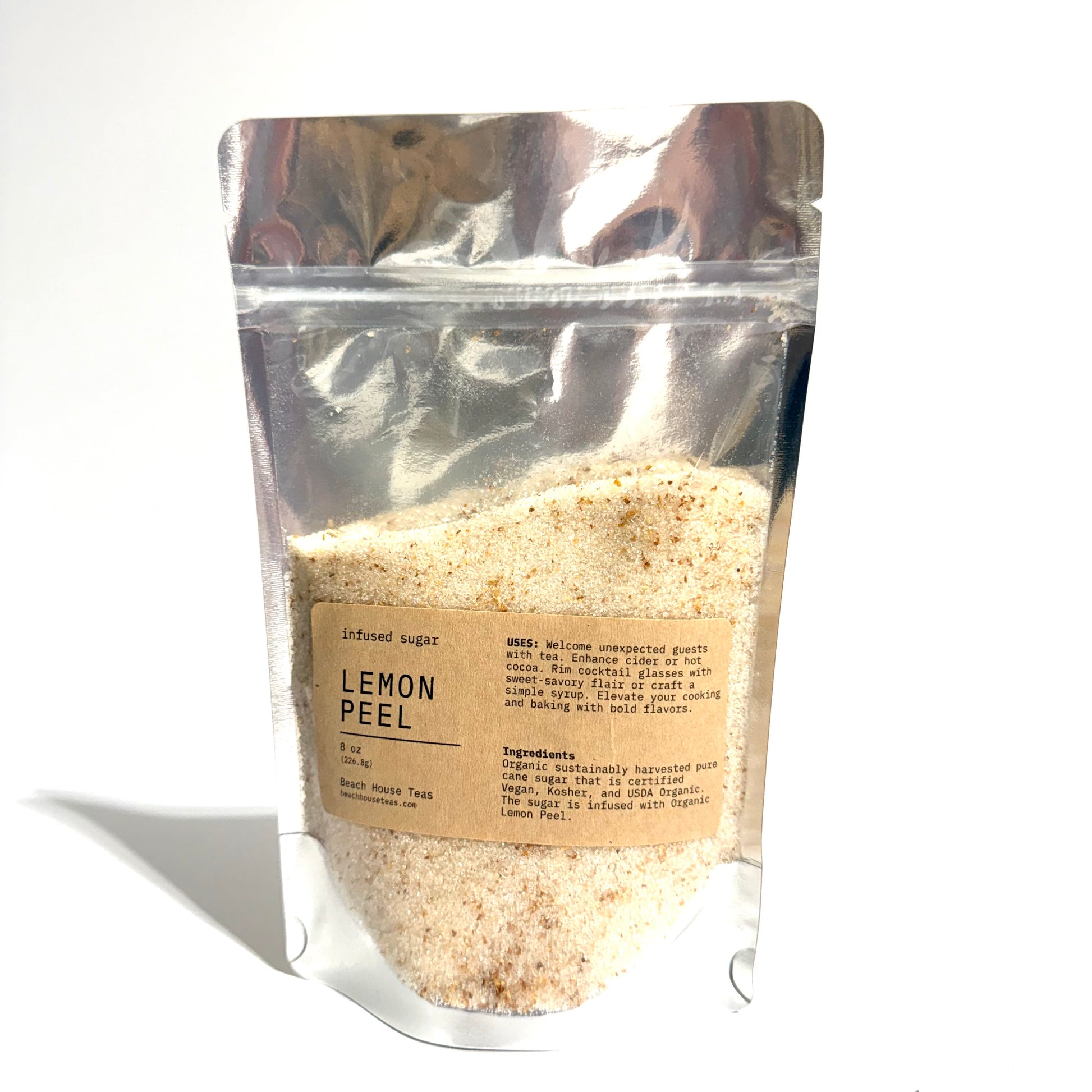 A stand-up resealable pouch of lemon peel infused sugar, showing the light tan sugar crystals inside through a clear bag with a kraft paper label.
