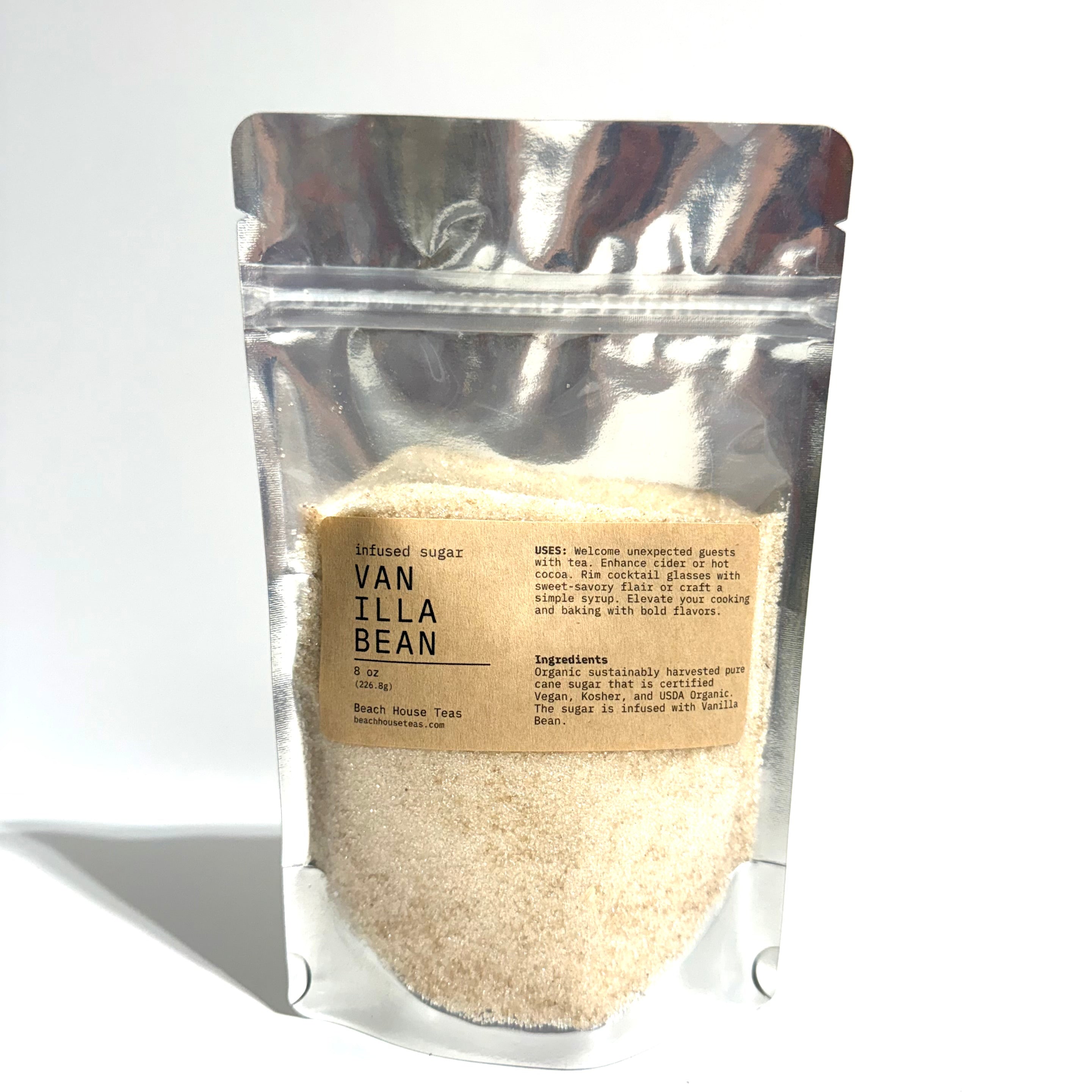 A stand-up pouch of vanilla bean powder with a kraft paper label, photographed on a white background with a soft shadow.