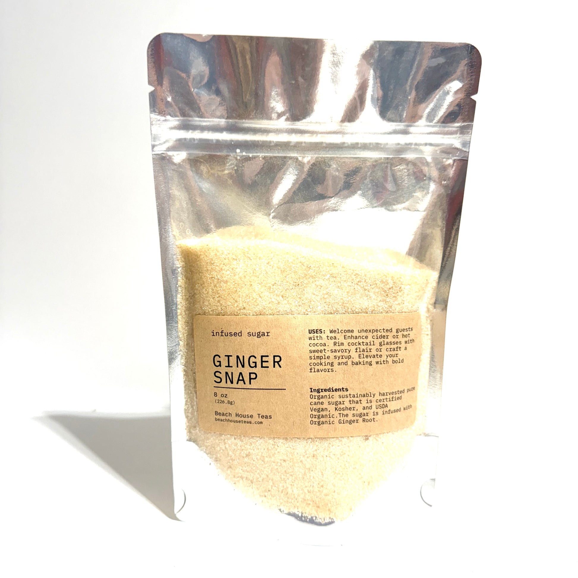A stand-up resealable pouch of ginger snap infused sugar, showing the light tan sugar powder through a clear plastic bag with a beige label.