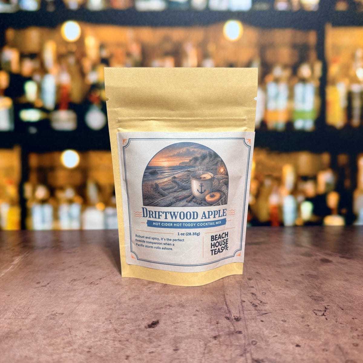 Driftwood Apple hot cider hot toddy cocktail mix by Beach House Teas, 1 oz pouch on a bar counter.