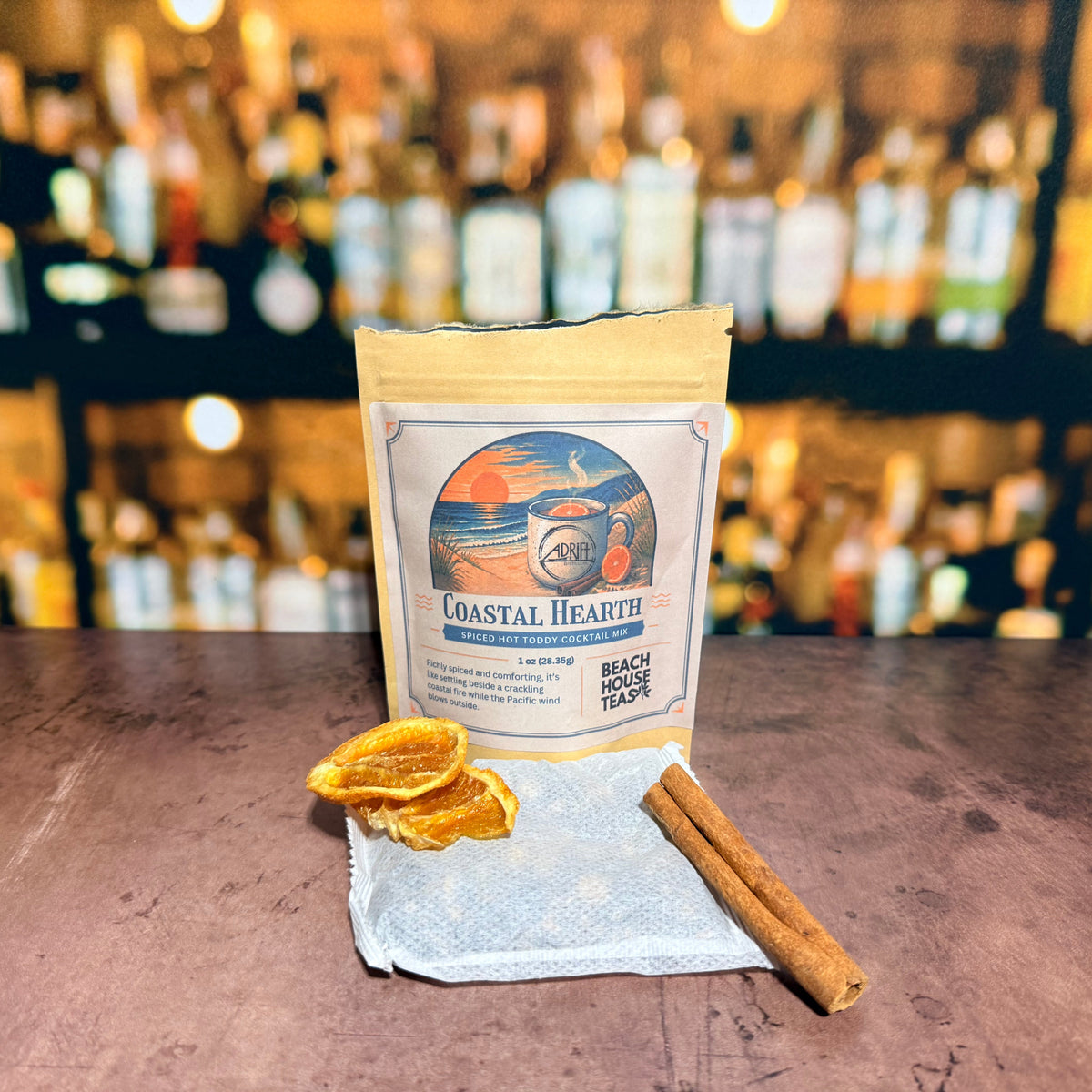 Coastal Hearth hot toddy mix pouch with a sachet, dried orange slices, and cinnamon sticks.