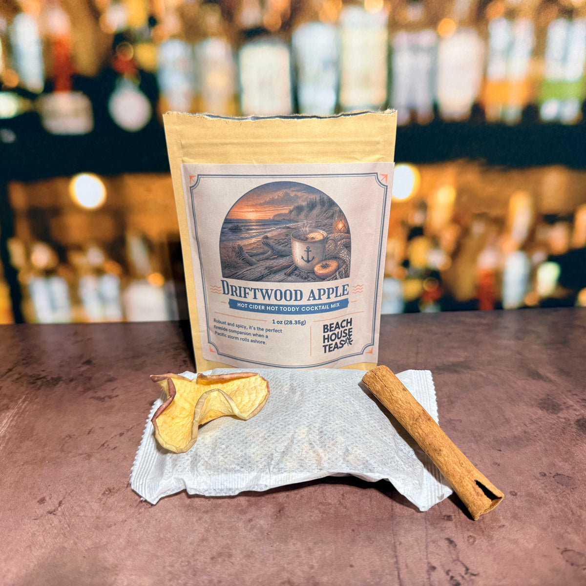 Driftwood Apple hot toddy mix pouch with a sachet, dried apple slice, and cinnamon stick.