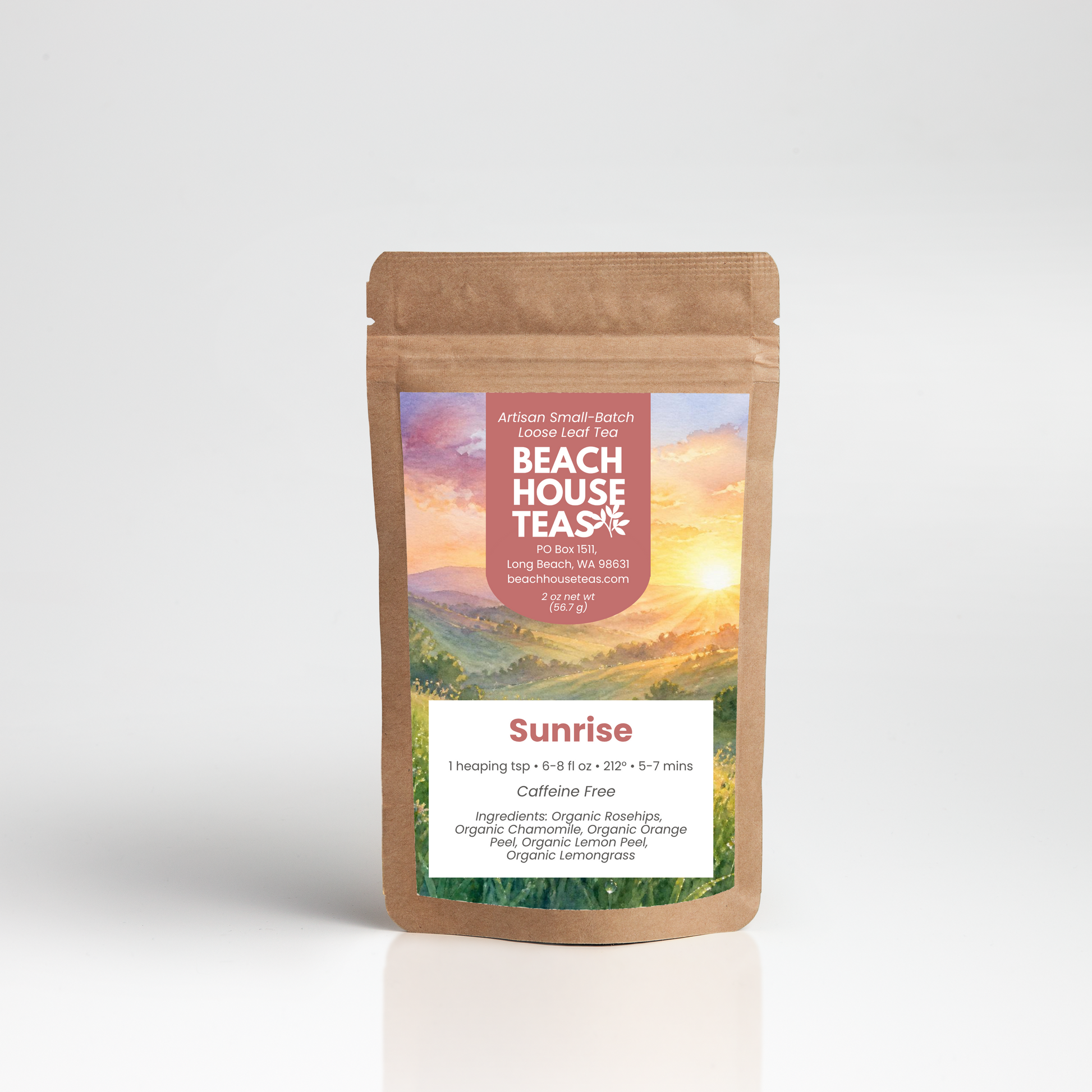 A stand-up kraft paper pouch of Beach House Tea's 'Sunrise' herbal tea, featuring a colorful label with a sunset landscape and white text, set against a clean white background with a soft reflection.