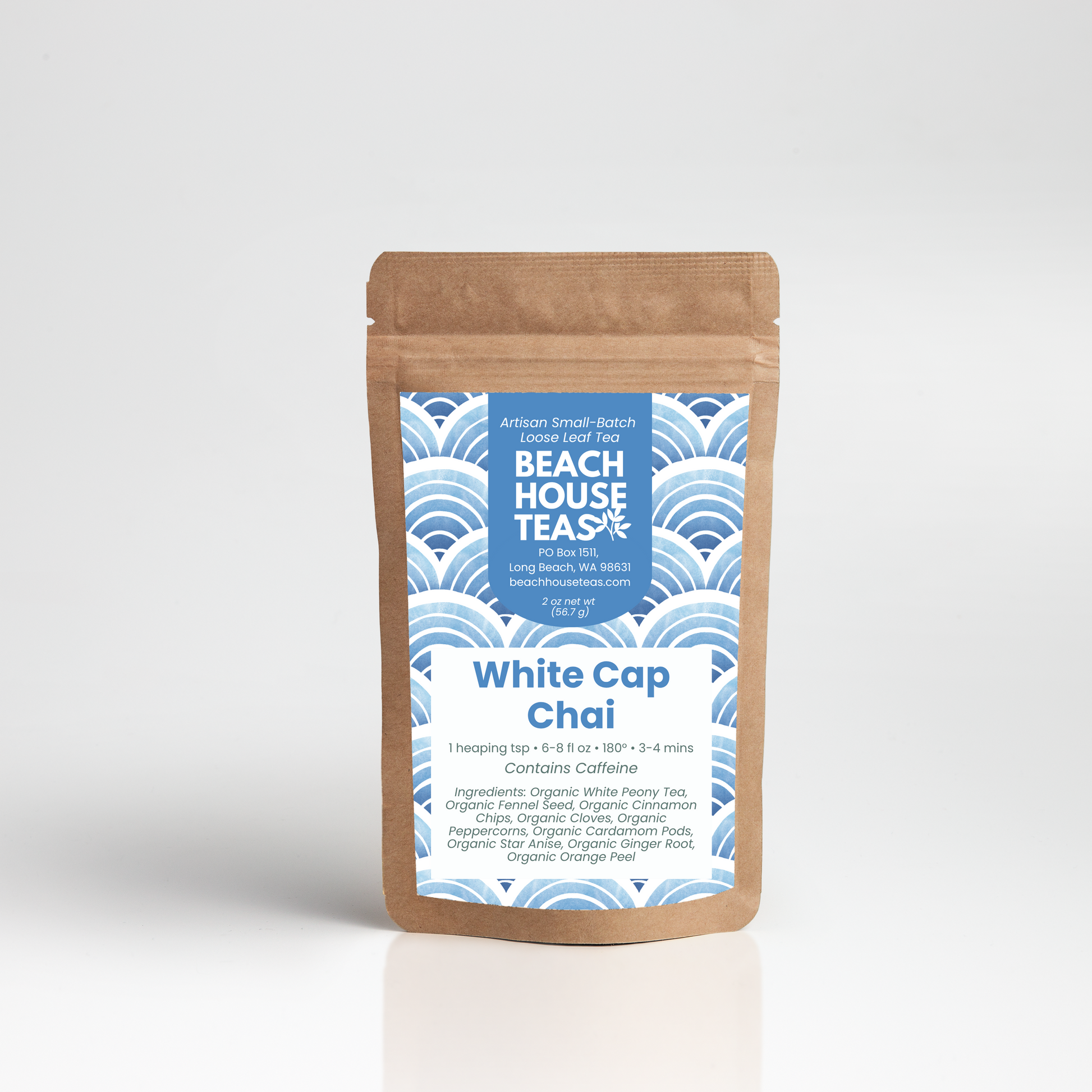 A kraft paper stand-up pouch of Beach House Teas White Cap Chai tea, featuring a blue and white wave pattern label, set against a clean white background with a soft reflection.