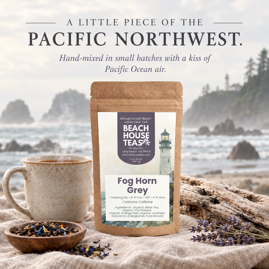 Fog Horn Grey pouch with a tea mug, loose leaves and driftwood against a misty Pacific Northwest coastline.