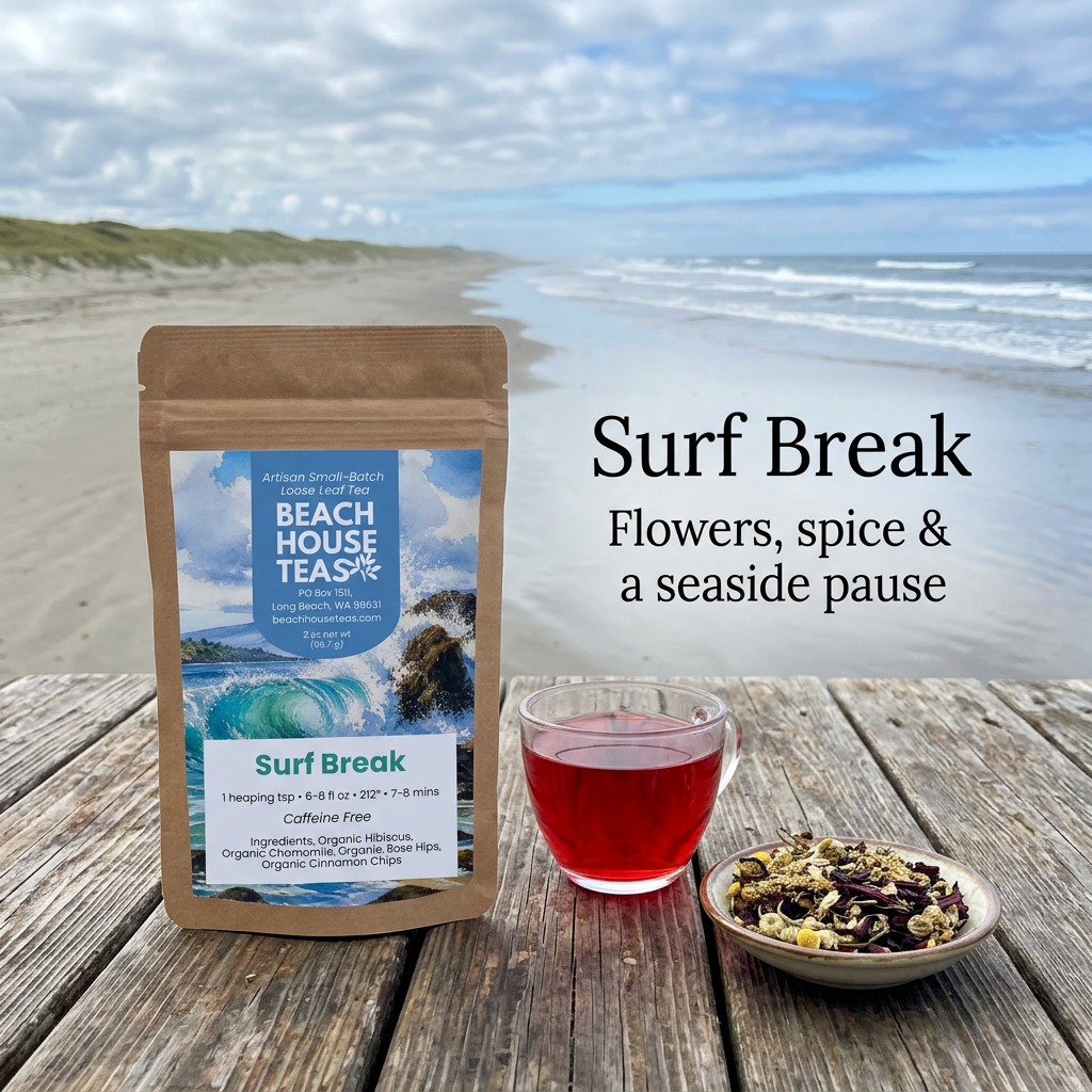 Surf Break pouch beside ruby herbal tea and loose blend on a weathered table overlooking a sandy shoreline.