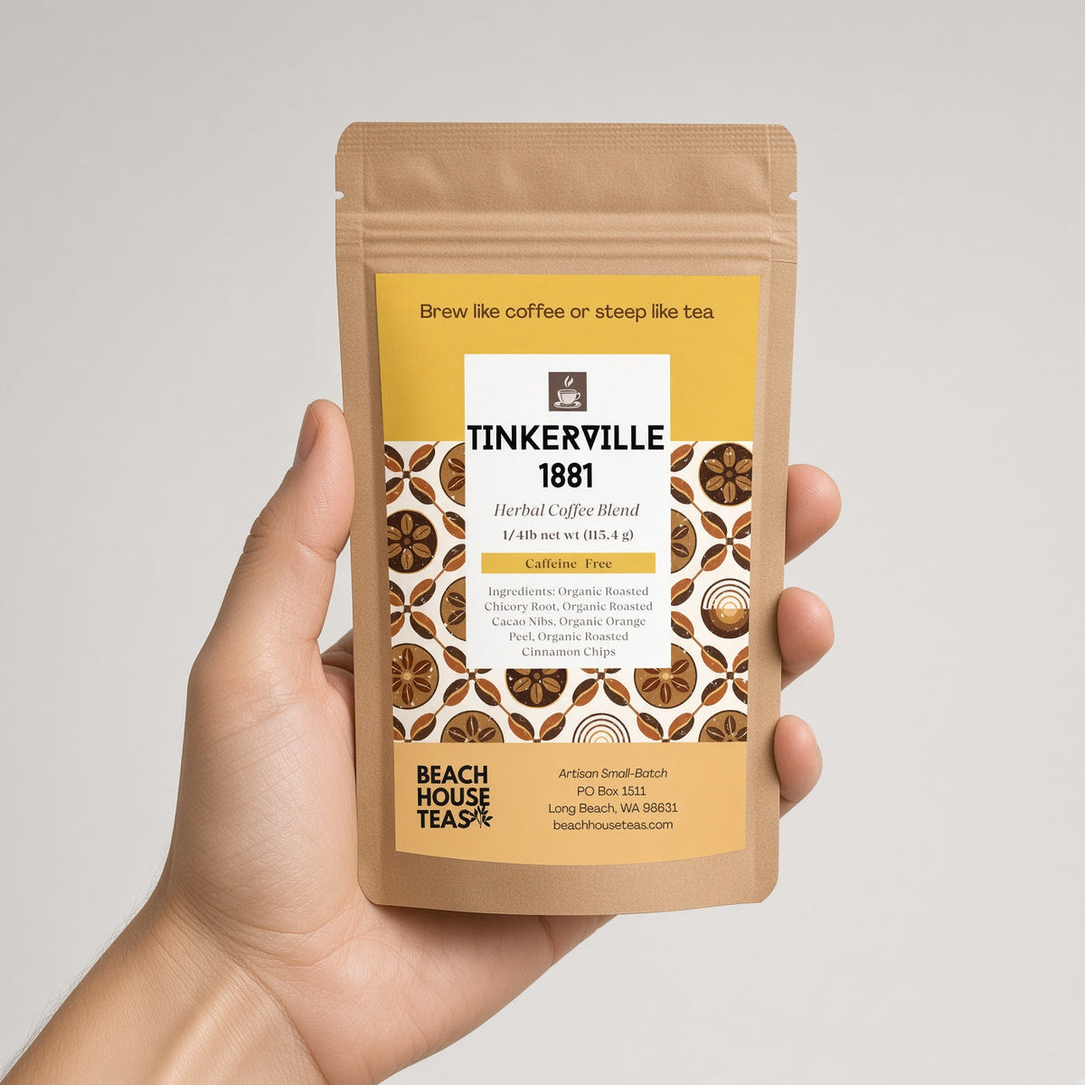 Hand holding a Tinkerville 1881 herbal coffee quarter-pound kraft pouch against a light background